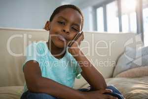 Boy talking on mobile phone in the living room at home