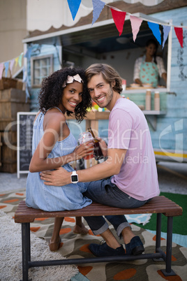 Portrait of happy couple sitting on table