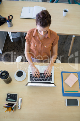 Female executive working over laptop at her desk