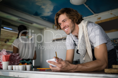 Waiter writing in notepad