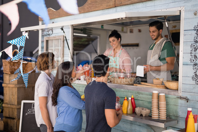 Smiling waiter taking order from customer