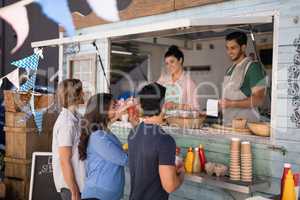 Smiling waiter taking order from customer