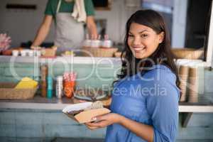 Smiling woman standing with snacks at counter