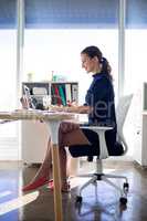 Female executive working over graphic tablet at her desk