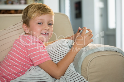 Boy playing video game in the living room at home