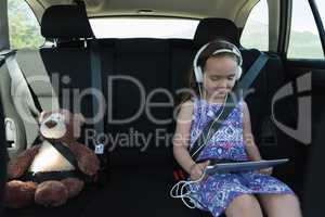 Cute girl listening music on headphone from digital tablet