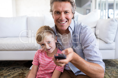 Father and son watching television in living room