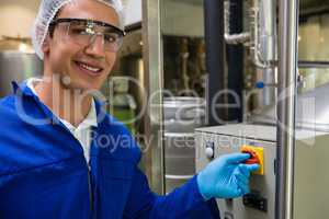 Portrait of smiling worker pressing button of machinery