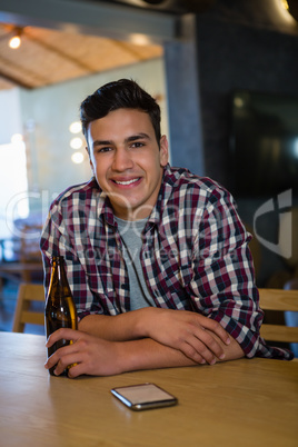 Portrait of smiling man holding beer bottle