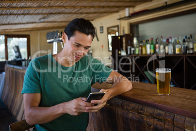 Man using phone while sitting at bar counter