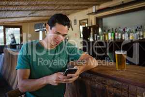 Man using phone while sitting at bar counter