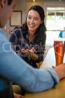 Smiling woman talking with friend at bar