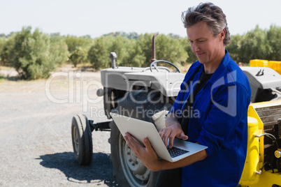 Worker using laptop on a sunny day