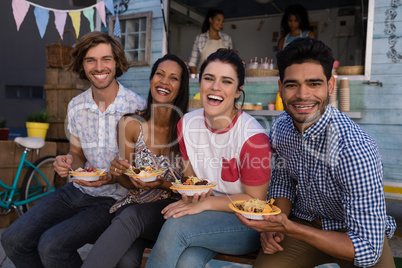 Portrait of friends sitting with snacks