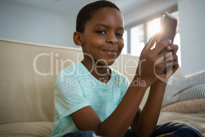 Boy using mobile phone in the living room at home