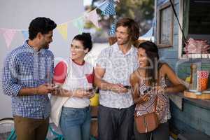 Friends interacting while using mobile phone at counter