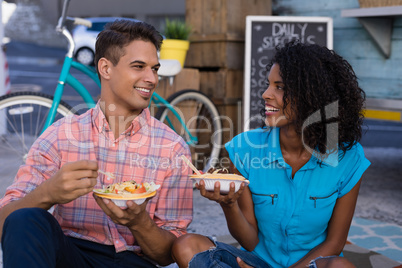 Happy couple looking at each other while having meal