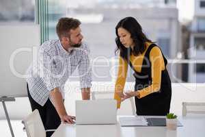 Business colleagues discussing over laptop