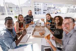 Portrait of happy executives having pizza