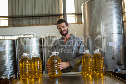 Worker holding a can of olive oil in factory