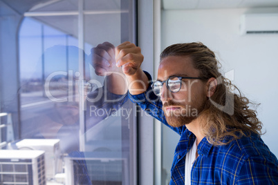 Male executive looking through window in office