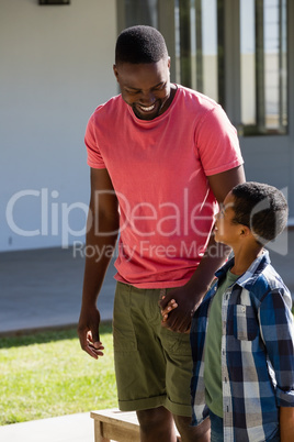 Father and son holding hands in the backyard