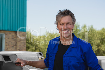 Smiling worker standing near tractor