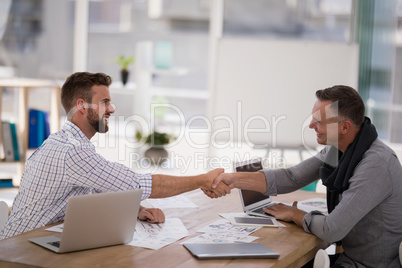 Business partners shaking hands in the office