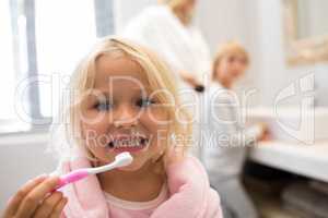 Girl brushing teeth in bathroom