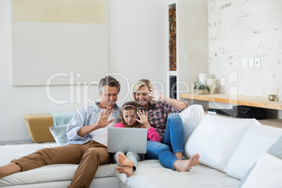 Family having a video call on laptop in living room
