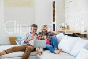 Family having a video call on laptop in living room