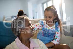 Granddaughter brushing her grandmothers hair in living room