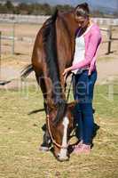 Full length of woman standing by horse