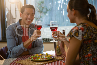 Smiling man with friend having red wine