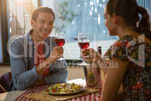 Smiling man with friend having red wine