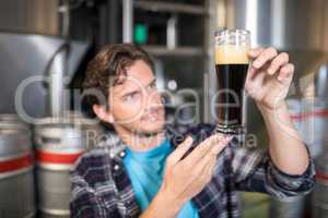 Worker examining beer in glass