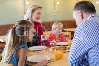 Family talking while enjoying appetizer in restaurant