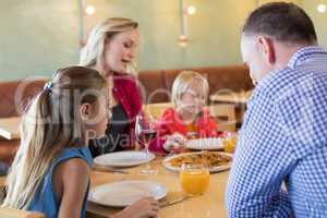 Family talking while enjoying appetizer in restaurant