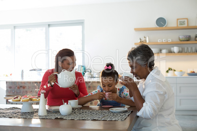 Happy multi-generation family having tea in dining table