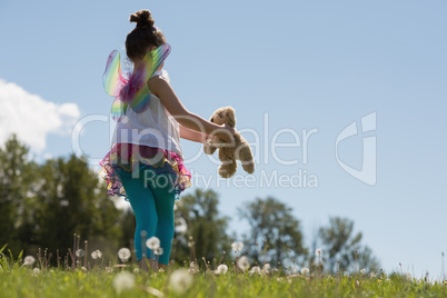 Smiling girl playing with teddy