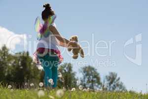 Smiling girl playing with teddy