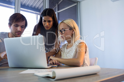 Executives discussing over laptop during a meeting