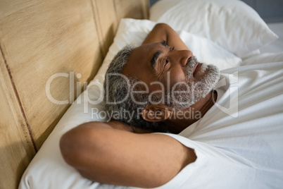 Senior man relaxing on bed in the bedroom