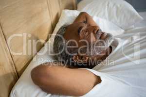 Senior man relaxing on bed in the bedroom