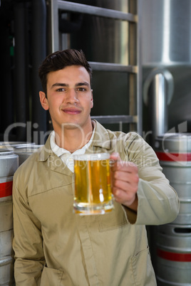 Portrait of male worker holding beer glass at brewery
