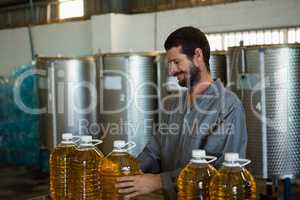 Worker checking a can of olive oil in factory