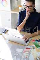 Female executive working over laptop at her desk