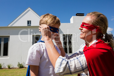 Mother and son pretending to be superhero in the backyard