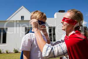 Mother and son pretending to be superhero in the backyard