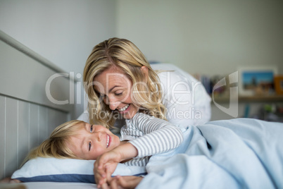 Mother and son having fun together in the bedroom